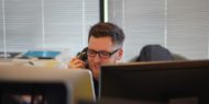 Man talking on phone at his desk